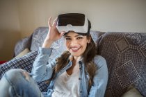 Young woman at home using Virtual Reality goggles — Stock Photo