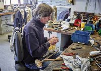 Instrument maker repairing trumpet in workshop — Stock Photo