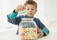 Хлопчик з цукерки jar rising jar cap — стокове фото