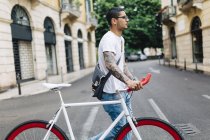 Young man walking with a bicycle in the city — Stock Photo