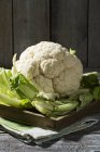 Fresh Cauliflower on wooden board with cloth — Stock Photo