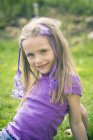 Retrato de uma menina sorridente sentada no jardim — Fotografia de Stock