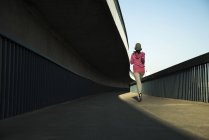 Jovem jogger feminino em movimento em uma ponte — Fotografia de Stock