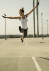 Jeune femme sautant en plein air au niveau du parking — Photo de stock
