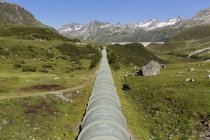 Austria, Vorarlberg, Vermunt, Bielerhohe, Tubo di approvvigionamento idrico dalla diga di Silvretta e montagne sullo sfondo — Foto stock