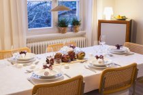 Artichokes on festive laid table in evening — Stock Photo