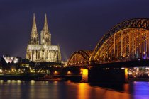 Germany, North Rhine-Westphalia, Cologne, view to lighted Hohenzollern Bridge and Cologne Cathedral in night — Stock Photo
