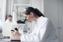 Retrato de jovem estudante usando microscópio em laboratório — Fotografia de Stock