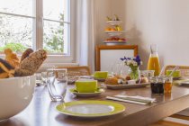 Vista della tavola della colazione apparecchiata contro finestra — Foto stock