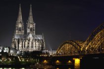 Germany, North Rhine-Westphalia, Cologne, Cologne Cathedral and Hohenhollern Bridge over the Rhine river by night — Stock Photo