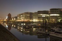 Germany, North Rhine-Westphalia, Duisburg, Inner harbour and office buildings, Five Boats, by night — Stock Photo