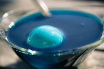 Крупным планом пасхальных яиц в банке синего красителя — стоковое фото