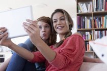 Zwei junge Freundinnen fotografieren sich mit Tablet-Computer — Stockfoto