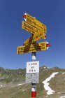 Austria, Vorarlberg, Señal en St Antonier Joch y colinas en el fondo - foto de stock