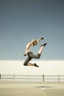 Giovane donna che salta a mezz'aria al livello del parcheggio — Foto stock