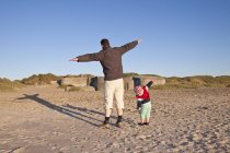 Dänemark, blavand, kleines mädchen und vater spielen am strand — Stockfoto