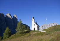 Italia, Alto Adige, Passo Gardena, Cappella in cima al passo con erba verde durante il giorno — Foto stock