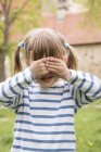 Kleines Mädchen bedeckt Augen mit Händen — Stockfoto