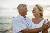 Seniorenpaar umarmt sich am Meer — Stockfoto