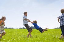 Kindergruppe spielt auf Wiese in der Natur — Stockfoto