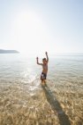 Португалія, хлопчик стоять у воді на пляжі — стокове фото