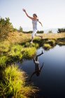 Австрия, Округ, Молодая женщина прыгает через горное озеро — стоковое фото