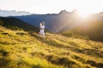 Áustria, Condado de Salzburgo, Jovem mulher correndo no prado alpino — Fotografia de Stock