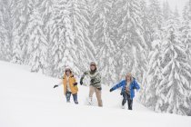 Junge erwachsene spazieren durch winterwald in salzburg — Stockfoto