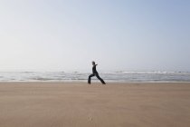 Belgique, Jeune femme faisant de l'exercice en mer du Nord — Photo de stock