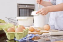 Boy stirring dough in bowl ta the kitchen — Stock Photo