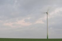 Wind turbine against cloudy sky — Stock Photo