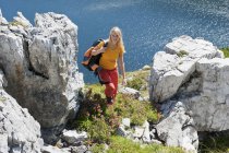 Escursionista tra le rocce vicino al lago — Foto stock