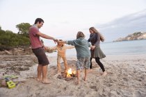 Friends dancing around camp fire — Stock Photo