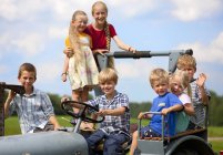 Kindergruppe sitzt in altem Traktor — Stockfoto