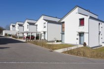 Alemania, Baden-Wurttemberg, Aldingen. Fila de casas unifamiliares modernas y coche aparcado - foto de stock