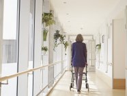 Seniorin mit Gehgestell auf Flur in Pflegeheim — Stockfoto