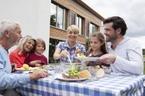 Family having barbecue at table in garden — Stock Photo