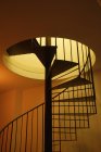 Spiral staircase with yellow light at home — Stock Photo