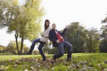 Couple playing in park, smiling, portrait — Stock Photo
