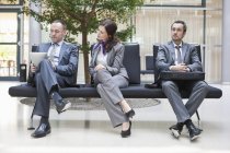 Business people sitting on bench in modern building — Stock Photo