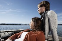 Couple assis sur la jetée au bord du lac — Photo de stock