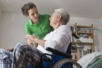 Man on wheelchair, talking with woman — Stock Photo