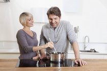 Mature couple cuisine des aliments dans la cuisine, souriant — Photo de stock