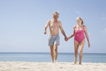 Couple sénior marchant sur la plage à l'océan Atlantique — Photo de stock