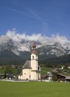 Austria, Tyrol, Going am Wilden Kaiser, View of town and green grass on foreground — Stock Photo