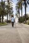 Spain, Mallorca, Palma, Couple walking along allee — Stock Photo