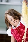 Mädchen spielt mit Spaghetti — Stockfoto