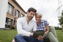Mature couple using digital tablet in garden — Stock Photo