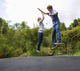 Молодий чоловік і жінка стрибають на батуті — стокове фото