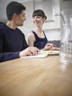 Hombre y mujer cenando, sonriendo - foto de stock